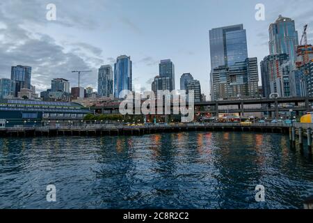 Seattle, Washington, USA - 20. juli 2018 - Skyline am Wasser in der Abenddämmerung mit Piers und Wolkenkratzern aus dem Downtown District Stockfoto