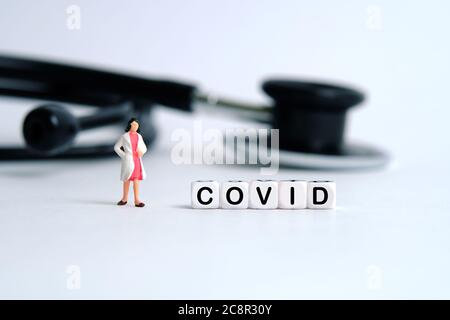 Pandemie Corona Virus konzeptuelle Miniatur Menschen Fotografie – Wort Perlen Alphabet covid mit Arzt Figur. Bildfoto Stockfoto