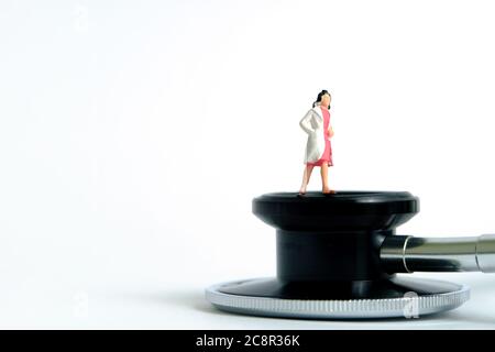 Gesundheit konzeptionelle Miniatur Menschen Fotografie – Frauen Arzt steht über Stethoskop. Bildfoto Stockfoto