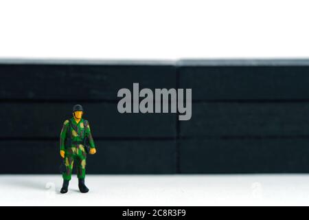 Pandemie Coronavirus konzeptuelle Miniatur-People-Fotografie – Lockdown-Illustration – Miniatur-Soldat stehen Wache vor der Barriere Wand. Bild P Stockfoto