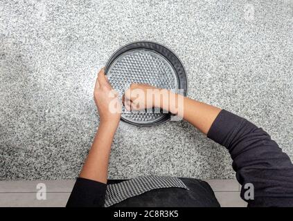 Draufsicht auf Hände, die eine Kuchenform in der Küche einfetten. Prozess für die Zubereitung eines Apfelkuchen Stockfoto