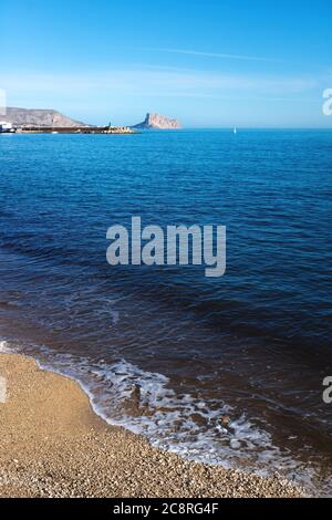 Blick auf den Strand über den tiefblauen Ozean auf den Felsen von Calpe, Costa Blanca, Spanien Stockfoto