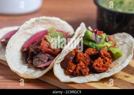 Mexikanisches Barbecue, Tacos von Carne Asada und Chorizo mit Guacamole und hausgemachten Salsas Stockfoto