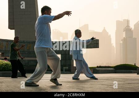 Tai Chi Übungen am Denkmal für die Helden des Volkes am Ufer des Bund von Shanghai früh am Morgen. Stockfoto