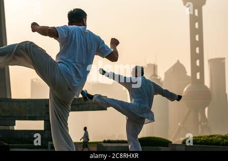 Tai Chi Übungen am Denkmal für die Helden des Volkes am Ufer des Bund von Shanghai früh am Morgen. Stockfoto