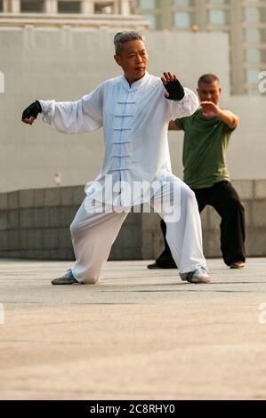 Tai Chi Übungen am Denkmal für die Helden des Volkes am Ufer des Bund von Shanghai früh am Morgen. Stockfoto