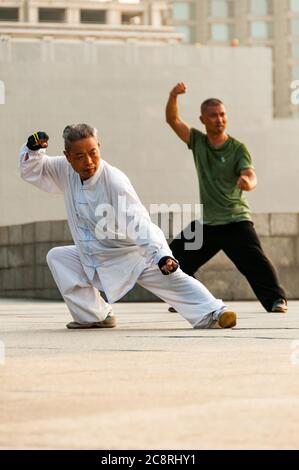 Tai Chi Übungen am Denkmal für die Helden des Volkes am Ufer des Bund von Shanghai früh am Morgen. Stockfoto