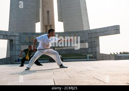 Tai Chi Übungen am Denkmal für die Helden des Volkes am Ufer des Bund von Shanghai früh am Morgen. Stockfoto