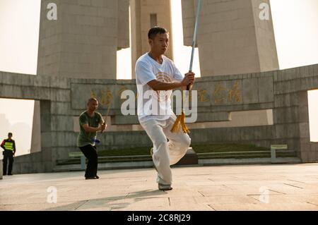 Tai Chi Übungen am Denkmal für die Helden des Volkes am Ufer des Bund von Shanghai früh am Morgen. Stockfoto