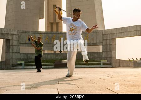 Tai Chi Übungen am Denkmal für die Helden des Volkes am Ufer des Bund von Shanghai früh am Morgen. Stockfoto