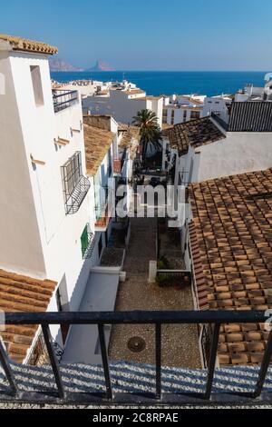 Steile Gasse mit Blick auf das Meer und den Felsen von Calpe in der Altstadt von Altea, Costa Blanca, Spanien Stockfoto