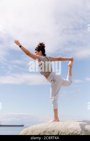 Junge Frau, die Yoga-Posen macht Stockfoto