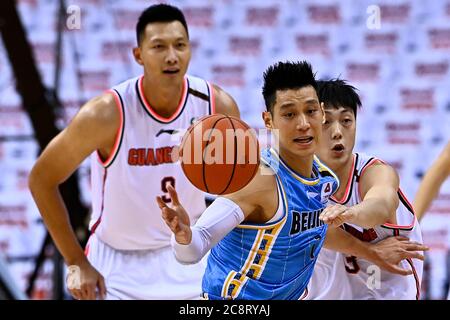 Peking, Chinas Provinz Shandong. Juli 2020. Jeremy Lin (C) von Beijing Ducks bricht bei einem Spiel zwischen Guangdong Southern Tigers und Beijing Ducks bei der 2019-2020 Chinese Basketball Association (CBA) Liga in Qingdao, Ostchina Shandong Provinz, 26. Juli 2020 durch die Verteidigung. Kredit: Guo Xulei/Xinhua/Alamy Live Nachrichten Stockfoto