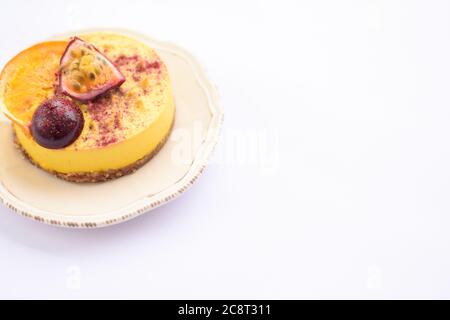 Roher hausgemachter Mango-Püree-Kuchen mit einem Stück Feige und Orange auf der Untertasse. Speicherplatz kopieren. Stockfoto