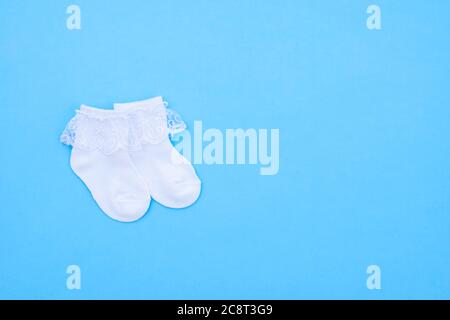 Paar weiß cute Baby Socken auf blauem Hintergrund. Baby Accessoires. Flach. Stockfoto