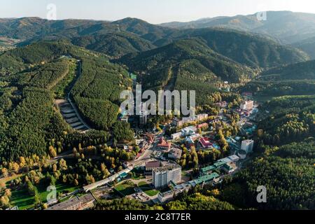 Luftaufnahme einer kleinen Stadt im Altai-Gebiet. Blick von oben auf den Ferienort Belokuricha. Vogelperspektive auf die Häuser zwischen den Wäldern auf der Stockfoto