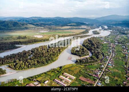 Luftaufnahme des Flusses Katun, im Altai-Gebirge. Draufsicht auf den Gebirgsfluss im Altai-Gebirge und das Dorf Aya. Altai-Gebiet. Stockfoto