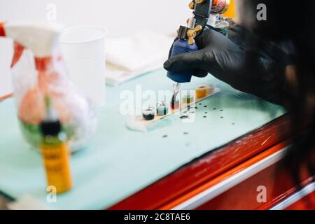 Tattoo Frau Laden der Tattoo-Maschine mit Tinte. Stockfoto