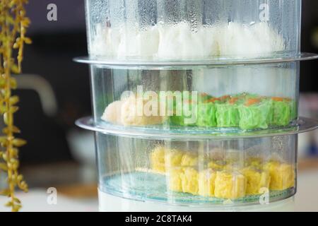 Kantonesische Shumai (Siu Mai) Dim Sum, Shrimps & Schweinefleisch Chinesische gedämpfte Knödel werden in einer gelben Wontonverpackung (Kanom Jeeb auf Thai) in einer warmen Mikrowelle verpackt. Stockfoto