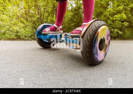 Beine des Mädchens Reiten auf selbstbalancierende Mini Hoverboard in City Park. Elektronischer Roller im Freien - persönliche tragbare Öko-Transport, Gyro Scooter Stockfoto