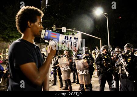 Portland, Oregon, USA. Juli 2020. Ein Mann auf einem BLM-Bullhorn hält Vorträge zur Polizei von Portland, nachdem sie die Proteste als Aufruhr und rechtswidrige Versammlung erklärt hatten. Proteste nehmen an Größe und Gewalt zu, da Demonstranten gegen US-Zoll- und Grenzschutzagenten in US-Militäruniform wüten, die von Präsident Donald Trump geschickt wurden, ihr Gerichtsgebäude übernahmen, ihre Waffen gegen die Massen drehten und in ihre Stadt einmarschierten, während sie gegen Polizeibrutalität gegen Afroamerikaner protestierten. Quelle: Amy Katz/ZUMA Wire/Alamy Live News Stockfoto