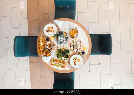 Blick von oben auf leckeres Essen mit verschiedenen Zutaten auf dem runden Tisch, in einem Restaurant oder Hotel. Hochwertige Fotos Stockfoto