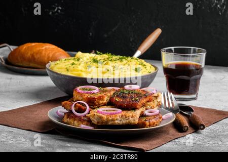 Gebratenes Schweinfilet Mignon, serviert mit Kartoffelpüree und roten Zwiebeln und Dill Stockfoto