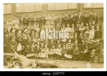 Original Anfang 1900 Edwardian Ära Postkarte von Männern und Jungen Arbeiter in einem Hof, alle tragen flache Kappen, Overalls, könnte eine Gießerei Gießen Rohre sein, einige der Männer könnten Musterbauer sein, geschrieben von Exeter in Devon, Juni 1907, Großbritannien Stockfoto