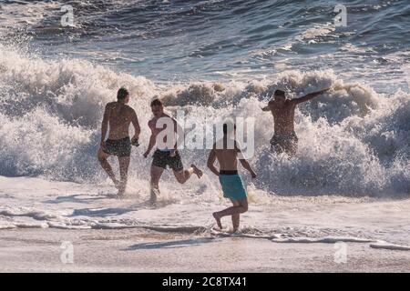 Männliche Urlauber verbringen ihren Urlaub im Meer am Fistral Beach in Newquay in Cornwall. Stockfoto