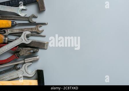 Happy Labor Day Konzept Baugruppe Heimwerkzeuge - Hammer, Säge, Schraubendreher, Meter, Zange, Schlüssel, Meißel auf grauem Hintergrund Holiday Card Top Stockfoto