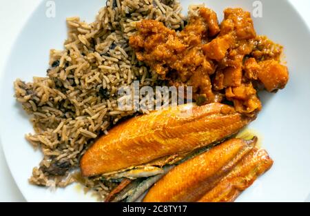 Kipper, brauner Reis mit Pilzen und Süßkartoffel-Curry Stockfoto