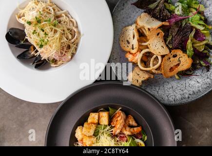 Verschiedene italienische traditionelle Gerichte und Salate auf dem Tisch. Stockfoto