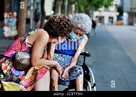 Eine Frau tröstet ihre gebrechliche, ältere Mutter, Barcelona, Spanien. Stockfoto