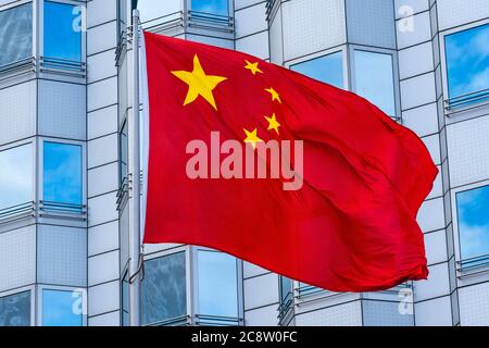 Berlin, Deutschland. Juli 2020. 24.07.2020, Berlin, die winkende rote Nationalflagge der Volksrepublik China mit den fünf gelben Sternen auf rotem Hintergrund bei Sonnenschein vor der chinesischen Botschaft in Berlin. Quelle: dpa/Alamy Live News Stockfoto