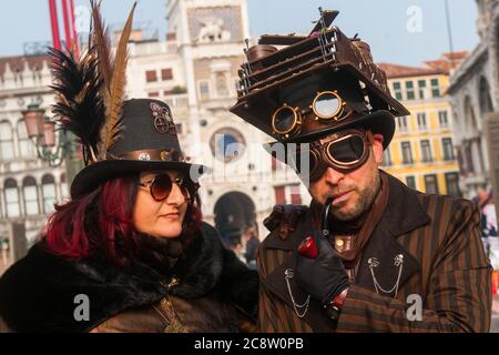 VENEDIG, ITALIEN - 28. FEBRUAR 2020: Zwei Steampunk-Masken posieren auf dem Markusplatz während des Karnevals in Venedig Stockfoto