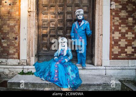 Ein schönes Paar Masken in hellblauen Kostümen posieren während des Karnevals in Venedig. Stockfoto