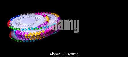 Circle Case mit bunten Nähen gerade Pins auf schwarzem Banner Hintergrund mit Reflexion und Copy Space Stockfoto