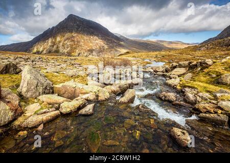 Wasser fließt durch die Gletschermoräne des Lake Idwal in Richtung Ogwen Valley und Pen yr Ole Wen Mountain, Snowdonia, Wales Stockfoto