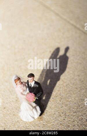 Standardfigur des Ehepaares auf beigem Boden. Keine Personen Stockfoto