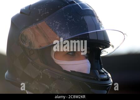 Symbolbild: Weibliche Rennwagenfahrerin trägt Helm und Sturmhaube (Model released) Stockfoto