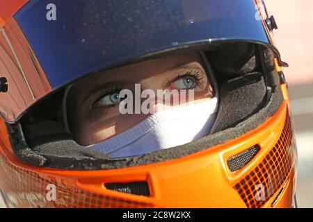 Symbolbild: Weibliche Rennwagenfahrerin trägt Helm und Sturmhaube (Model released) Stockfoto