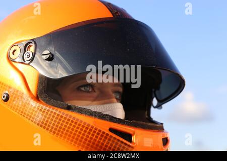 Symbolbild: Weibliche Rennwagenfahrerin trägt Helm und Sturmhaube (Model released) Stockfoto