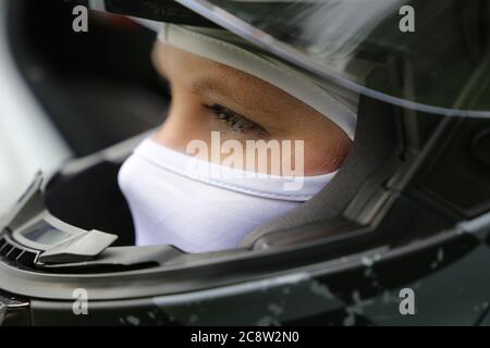 Symbolbild: Weibliche Rennwagenfahrerin trägt Helm und Sturmhaube (Model released) Stockfoto