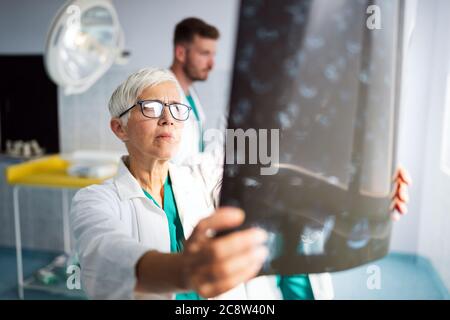 Ärzte diskutieren die Diagnose des Patienten und betrachten Röntgenaufnahmen in einem Krankenhaus Stockfoto