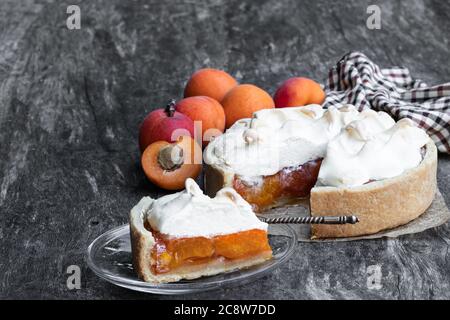 Leckere Meringuekuchen mit frischer Aprikose auf Holztisch Stockfoto