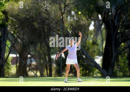 Eine ältere Dame streckt sich während eines lokalen Tennisturniers in Victoria Australia für den Tennisball Stockfoto