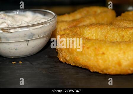 Zwiebelringe und ein Glas-Topf mit Sauce. Nahaufnahme Stockfoto