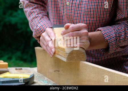 Zimmermannin arbeitet mit Flugzeug, Nahaufnahme. DIY, Holzwerk Konzept. Stockfoto