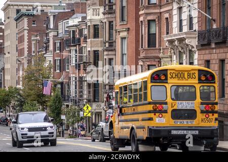 Ein gelber Schulbus fährt durch die Beacon Street in der Innenstadt von Boston. Die Häuser und Wohnungen in dieser exklusiven Straße gehören zu den teuersten Wohngebieten der Stadt. (08. Oktober 2019) weltweit Stockfoto