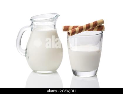 Kanne und Glas mit Milch und Waffeln isoliert auf weißem Hintergrund Stockfoto